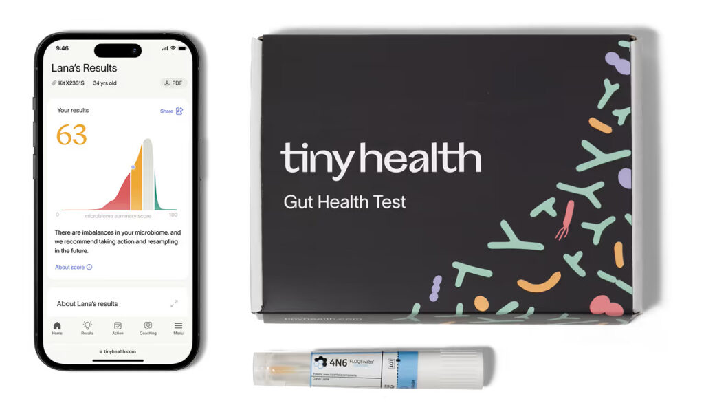 A Tiny Health Gut Health Test kit, a sample collection tube, and a smartphone displaying Adult Gut Health Test results with a score of 63 on a graph. , Kiara Health Fertility